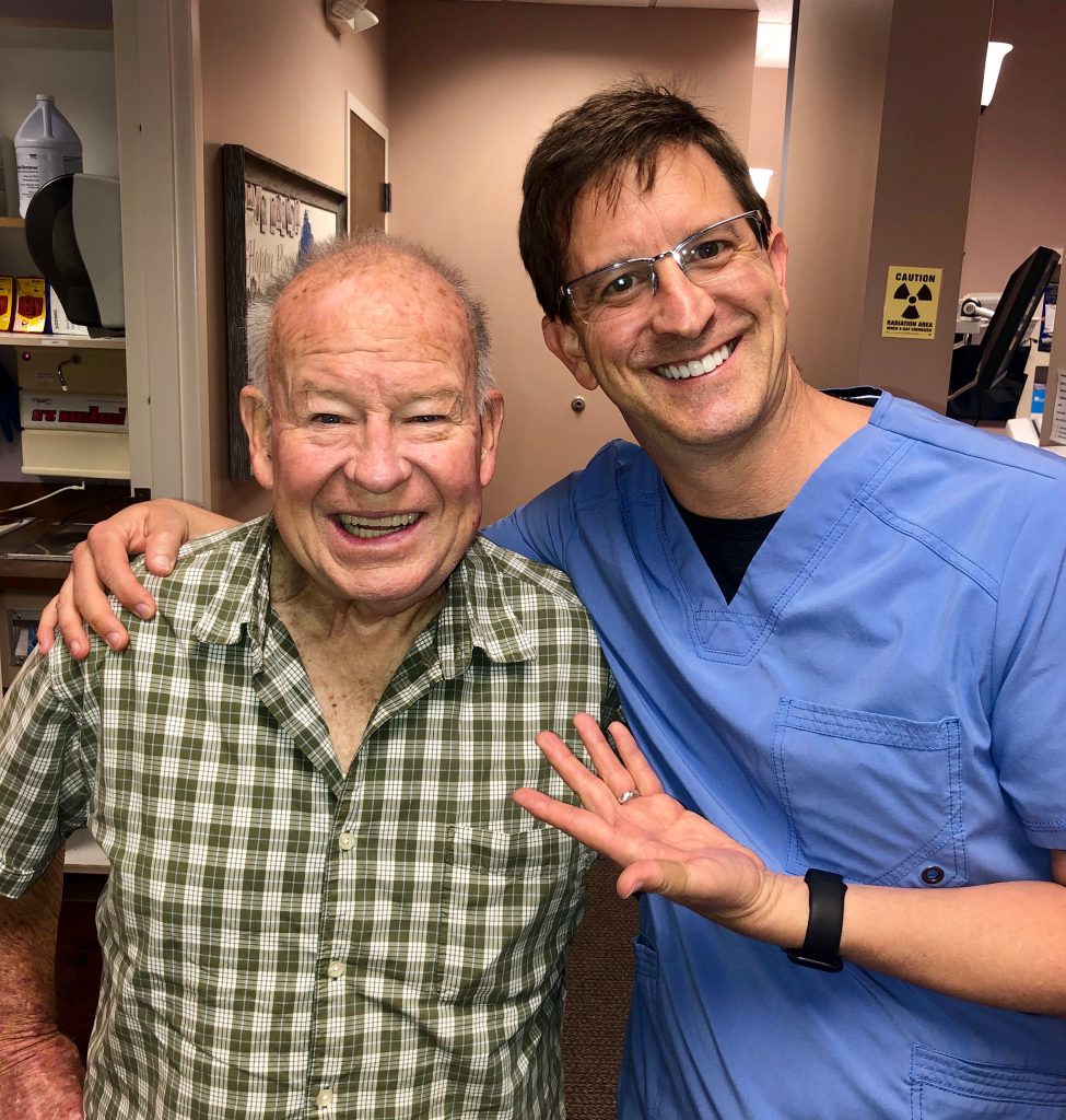 Happy Charlotte dentist patient with dentures, dental implants